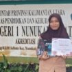 Shalsa Bhila menunjukkan piagam penghargaan atas karya novelnya