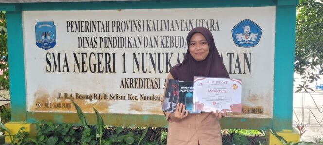 
					Shalsa Bhila menunjukkan piagam penghargaan atas karya novelnya