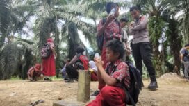 Sejumlah anak TKI beristirahat di patok batas negara seusai pulang sekolah di Sebatik, Indonesia