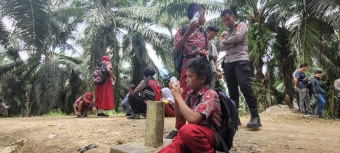 
					Sejumlah anak TKI beristirahat di patok batas negara seusai pulang sekolah di Sebatik, Indonesia