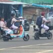 Sejumlah anak sekolah mengendarai sepeda listrik di jalan raya