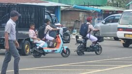 Sejumlah anak sekolah mengendarai sepeda listrik di jalan raya