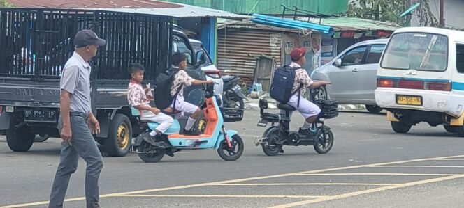 
					Sejumlah anak sekolah mengendarai sepeda listrik di jalan raya