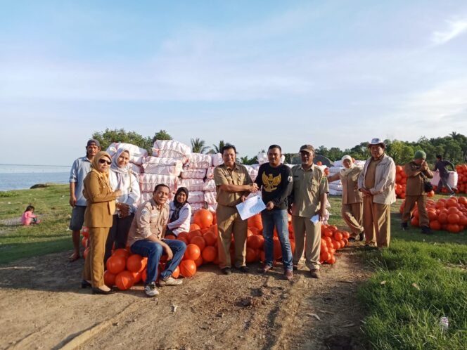 
					Kadis DKP Nunukan, Suhadi, menyerahkan bantuan pelampung kepada pembudidaya rumput laut.