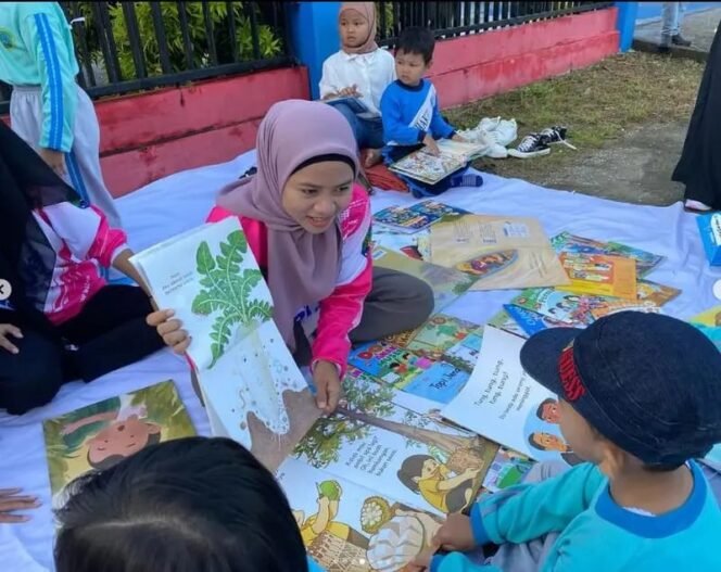 
					Pemandangan salah satu guru mengajar anak anak membaca di   taman.
