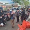 Aksi komunitas fitness Nunukan saat membagikan takjil di lampu merah pertigaan Pelabuhan Tunon Taka dan Bandara, di bawah monumen patung tani/selamat datang, Nunukan Timur, Selasa (25/3/2025).