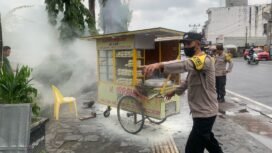 Aksi polisi bantu padamkan api yang menyembur dari kompor gas salah satu pedagang Bakpao di Alun Alun Nunukan,