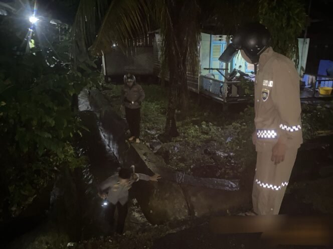 
					Sejumlah polisi melakukan pencarian warga yang jatuh ke parit dan hanyut terbawa arus, Jumat (28/3/2025) malam.