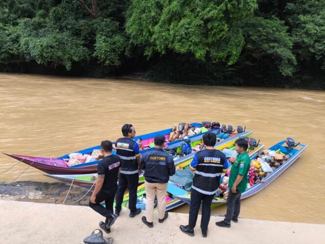 
					Sejumlah petugas di PLBN Labang, memeriksa kapal kapal yang membawa barang keluar masuk Indonesia - Malaysia,