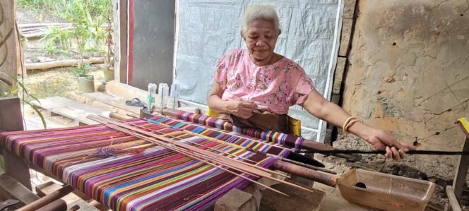 
					Maria Sommi Olla (65) sedang menenun kain khas NTT.