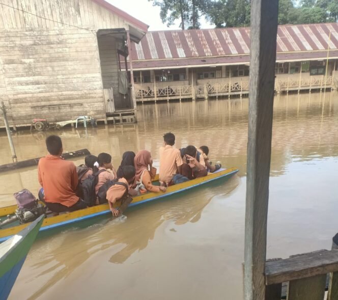
					Sejumlah murid sekolah di Sembakung menaiki ketinting untuk menuju sekolahnya. Wilayah pedalaman Sembakung menjadi salah satu wilayah langganan banjir kiriman Malaysia saban tahun.
