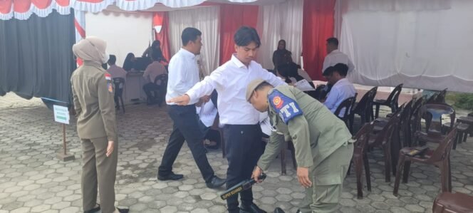 
					Petugas keamanan di BKPSDM Nunukan memeriksa tubuh salah satu peserta tes PPPK sebelum masuk ruang ujian,