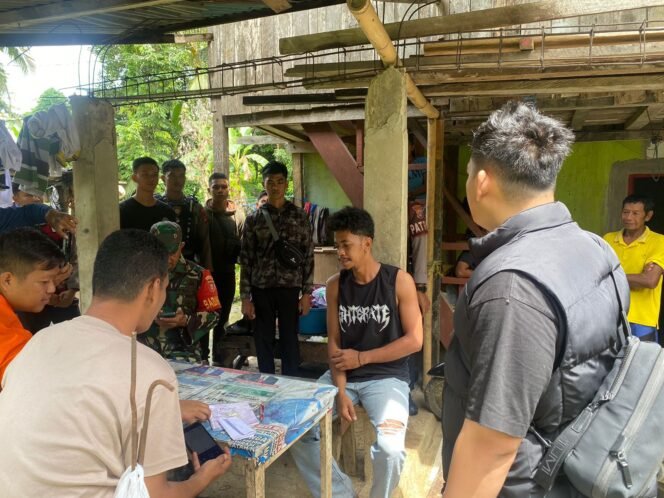 
					Jefendi (mengenakan kaos tanpa lengan) saat dimintai keterangan aparat keamanan.