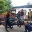 sejumlah petugas Damkar mencoba mengeluarkan ular kobra yang masuk body motor salah satu warga,