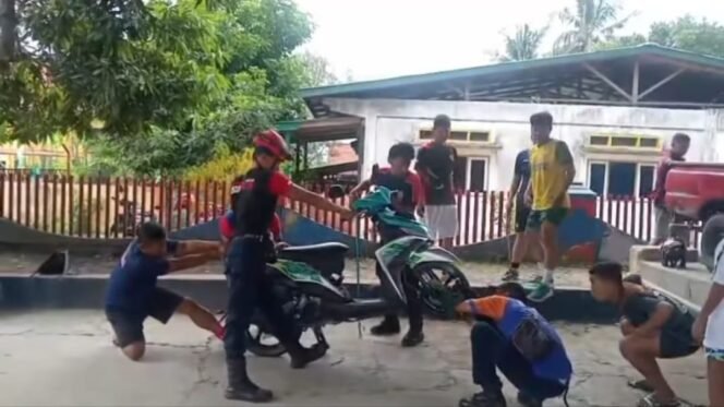 
					sejumlah petugas Damkar mencoba mengeluarkan ular kobra yang masuk body motor salah satu warga,