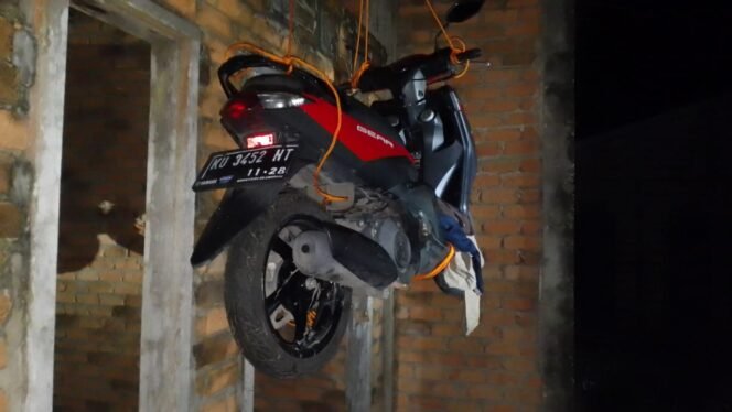 
					Motor matic diduga milik pencuri yang gagal beraksi digantung di bawah atap rumah warga sebagai peringatan,