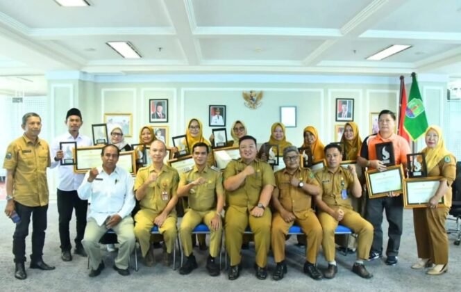 
					Bupati Nunukan, Irwan Sabri bersama Pejabat DLH dan Kepala Sekolah penerima Piagam Adiwiyata melakukan sesi foto bersama setelah penyerahan piagam. Dok.Prokopim.