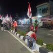 Sejumlah pemuda Nunukan saat kerja bhakti memasang bendera merah putih di median jalan protokol, di malam jelang 1 Agustus 2025. 