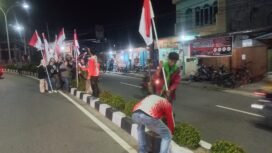 Sejumlah pemuda Nunukan saat kerja bhakti memasang bendera merah putih di median jalan protokol, di malam jelang 1 Agustus 2025. 