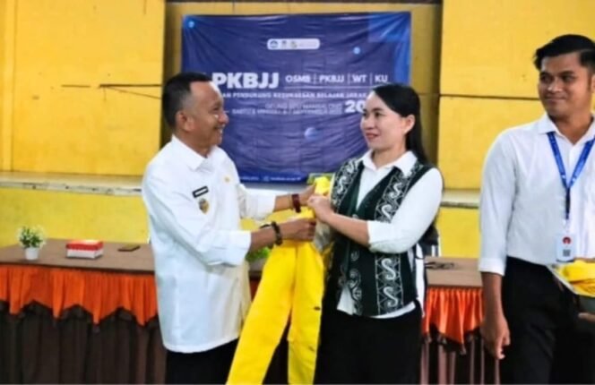 
					Wakil Bupati Nunukan, Hermanus, pakaikan jaket Almamater UT kepada istri, beri teladan dan ajakan kuliah bagi warga pedalaman Nunukan. Dok.Prokopim.