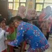 Sekda Nunukan, Jabbar saat memakaikan seragam gratis bagi murid SDN 001 Nunukan Selatan. Pembagian seragam sekolah gratis dilakukan serentak di Kabupaten Nunukan, dipimpin Bupati Nunukan Irwan Sabri secara daring dari dataran tinggi Krayan, Jumat (24/10/2025).