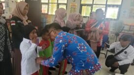 Sekda Nunukan, Jabbar saat memakaikan seragam gratis bagi murid SDN 001 Nunukan Selatan. Pembagian seragam sekolah gratis dilakukan serentak di Kabupaten Nunukan, dipimpin Bupati Nunukan Irwan Sabri secara daring dari dataran tinggi Krayan, Jumat (24/10/2025).