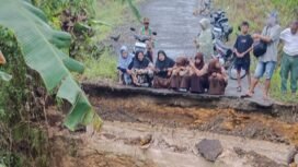 Sejumlah murid madrasah terduduk dan melamun melihat puing jembatan menuju sekolahnya ambruk akibat banjir, Rabu (5/11/2025) malam. Dok.Andre Pratama.