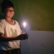 Ilustrasi : Anak kecil menyalakan lilin saat lampu PLN mati.
