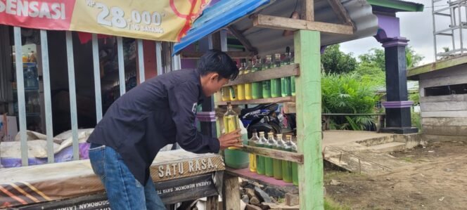 
					Salah satu warga Nunukan membeli bensin botolan yang selalu terpajang di hampir semua warung pinggir jalan.