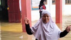 Seorang ibu berada di tengah banjir yang merendam sekolah SD di Sembakung. Dok.BPBD Nunukan.