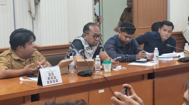 Romy Rieska Setiadi (kiri mengenakan seragam ASN) dan Mutiq Hasan Nasir (baju batik) saat hadir dalam RDP masalah dugaan demosi di Ruang Ambalat, Gedung DPRD Nunukan, Selasa (28/4/2026).