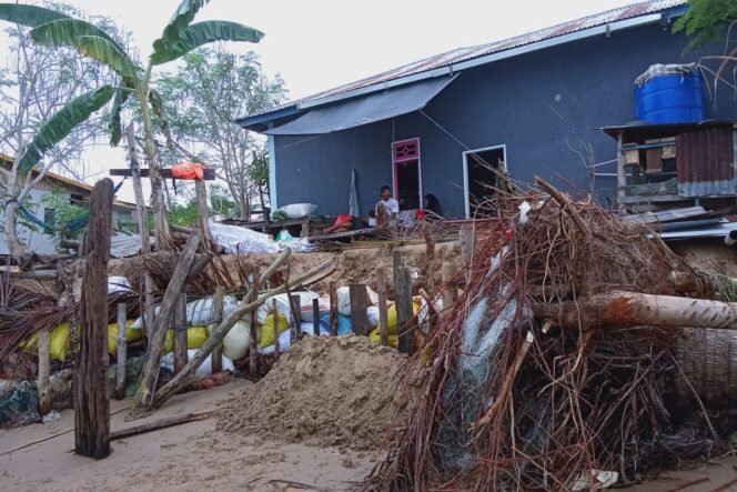 
					Gambaran kondisi salah satu rumah warga pulau Sebatik yang terdampak abrasi. Mereka selalu menancapkan kayu pagar pembatas dan tumpukan karung berisi pasir sebagai tanggul peredam ombak. Dok.Lisda.