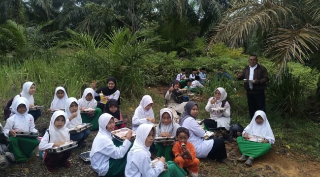 Puluhan murid MI Darul Furqon menikmati MBG di pinggir kali. Jembatan menuju sekolah ambruk memaksa anak anak nekat menyeberangi sungai banjir untuk menuju sekolah. Dok.Adnan Lolo.