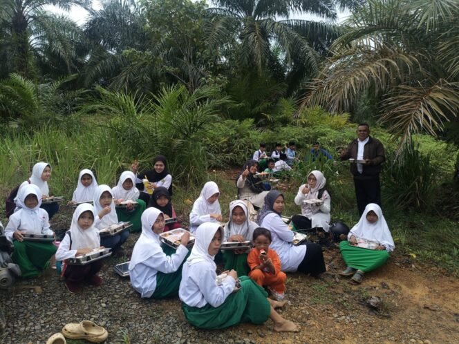 
					Puluhan murid MI Darul Furqon menikmati MBG di pinggir kali. Jembatan menuju sekolah ambruk memaksa anak anak nekat menyeberangi sungai banjir untuk menuju sekolah. Dok.Adnan Lolo.