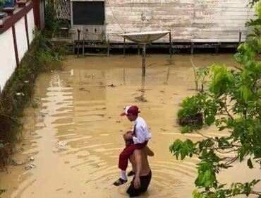 Murid SD 004 Sei Limau Sebatik dipanggul kakeknya dan diantar ke sekolah. Hujan deras yang mengguyur Pulau Sebatik semalaman mengakibatkan sebagian besar wilayah Sebatik kebanjiran. Dok.Ismail.