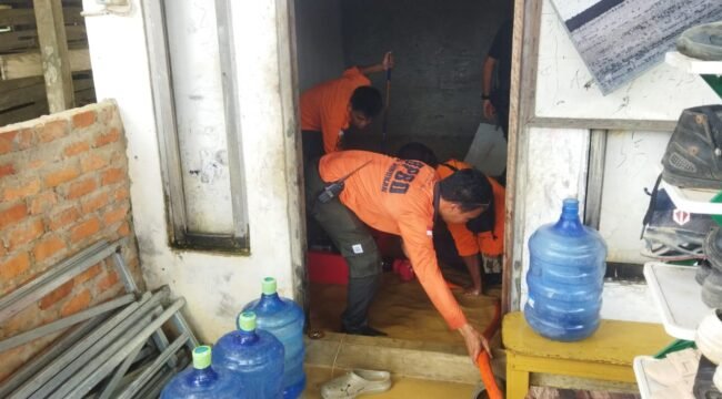 Sejumlah petugas BPBD Nunukan membantu menyedot genangan banjir di rumah warga Pulau Sebatik. Hujan deras Senin (13/7/2026) dini hari mengakibatkan sejumlah sungai meluap dan membanjiri 4 kecamatan di perbatasan RI - Malaysia ini. Dok.BPBD Nunukan.