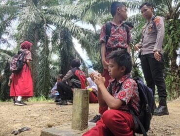 Sejumlah anak anak TKI Malaysia, buruh perkebunan kelapa sawit yang bersekolah di Sebatik. Mereka beristirahat di patok batas negara dan masih setengah jalan menuju mess di Malaysia.