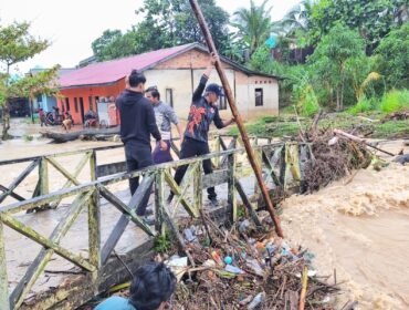 Petugas BPBD Nunukan sedang menyingkirkan sampah di salah satu jembatan kayu agar aliran air bisa lancar. Dok.BPBD Nunukan.