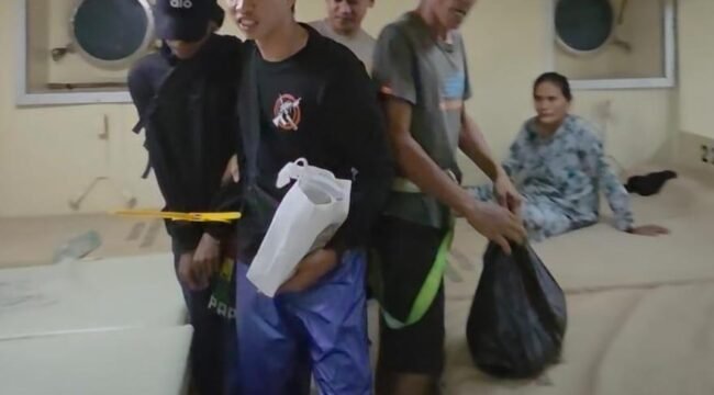LIN (topi hitam dengan borgol kuning) pelaku pencurian dan penggelapan motor Honda Beat milik warga Malinau,  saat diamankan polisi di atas KM Bukit Siguntang, Tarakan. Dok.Polsek Nunukan.