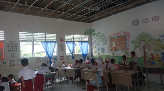 Murid SDN 004 Sebatik tengah belajar di kelas yang plafonnya ambruk karena atap seng yang bocor. Dok.Sittiara Razak.