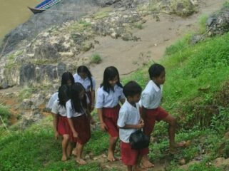 Anak anak sekolah di wilayah Lumbis berangkat sekolah dengan menyeberangi sungai karena tak ada akses layak.