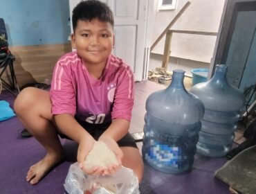 Bocah di Nunukan menunjukkan beras lokal yang mengalami kenaikan harga Rp 16.000/Kg dari sebelumnya Rp 13.000/Kg.