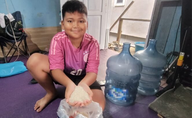 
					Bocah di Nunukan menunjukkan beras lokal yang mengalami kenaikan harga Rp 16.000/Kg dari sebelumnya Rp 13.000/Kg.