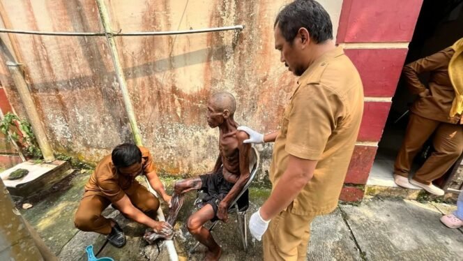 
					Petugas Peksos memandikan orang terlantar.Dok.DSP3A Nunukan.